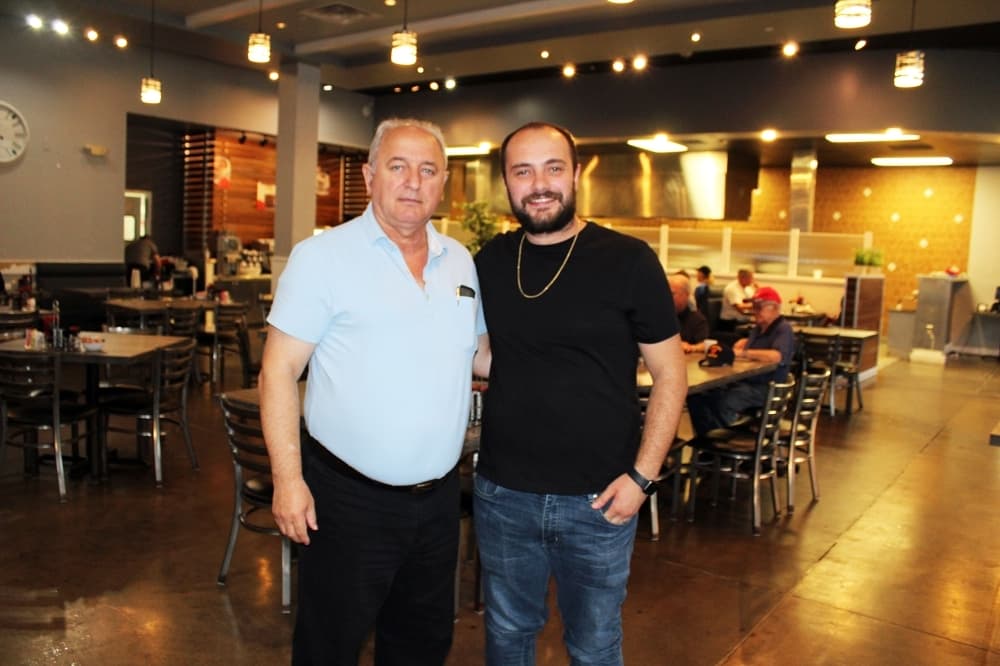 Arsim Ibishi (right) opened Hydeout Cafe after learning about the restaurant business from his father Nebi Ibishi (left). (Karen Chaney/Community Impact Newspaper)