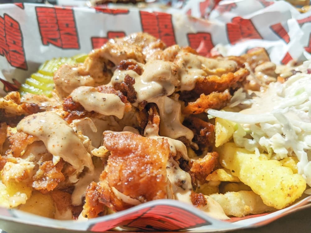 Houston Hot Fries ($12): French fries are piled high with diced hot chicken, homemade slaw, pickles and Scooter Sauce. (Jishnu Nair/Community Impact Newspaper)