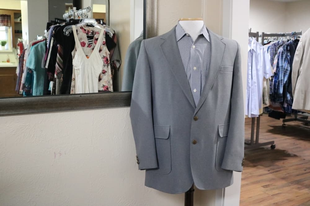 suit coat in front of racks of clothes