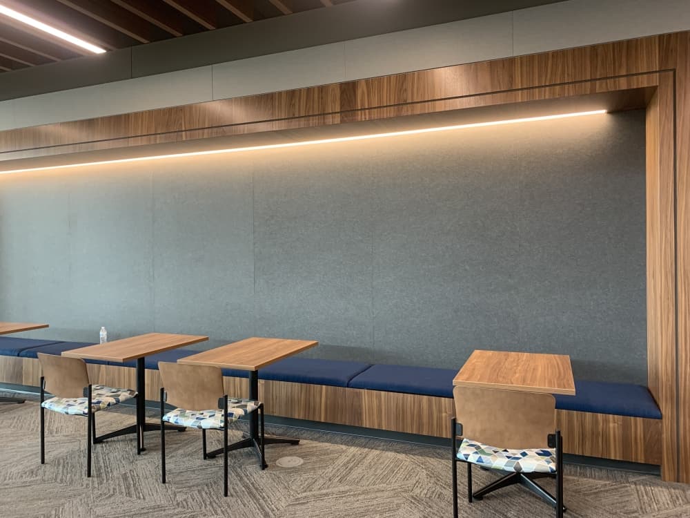 This gray wall doubles as a seat back and tack board for college announcements. (Brooklynn Cooper/Community Impact Newspaper)