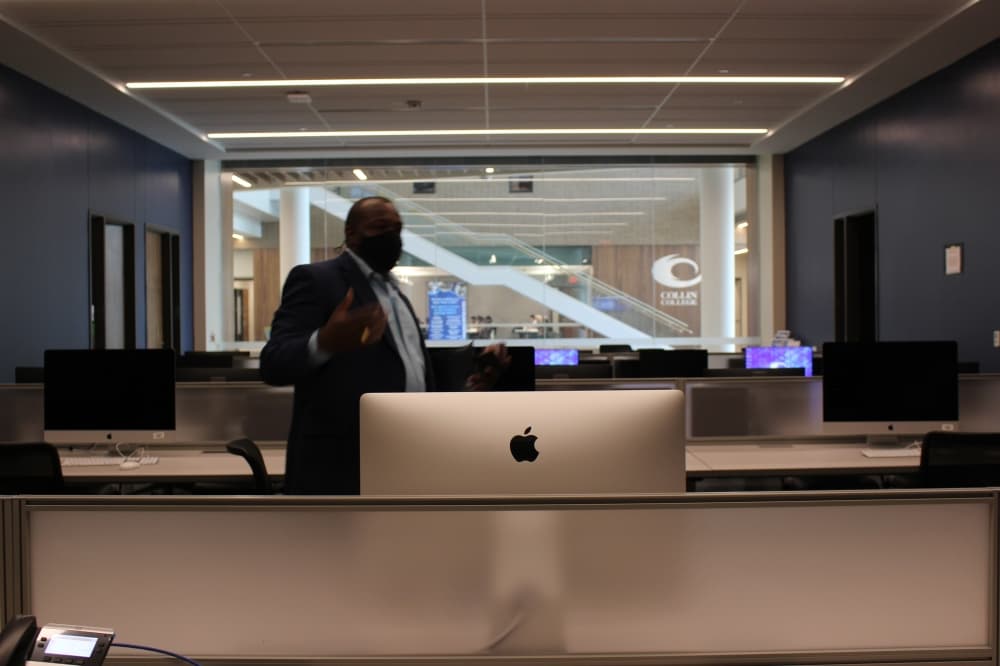 Gregory Newman, associate dean of Collin College's Frisco campus, explains the "fish bowl," what he calls the career coaching lab for its glass wall that looks into the IT Center's lobby. (Brooklynn Cooper/Community Impact Newspaper)