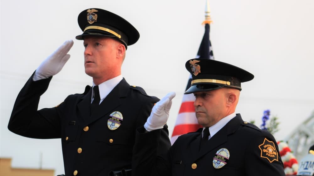 Members of the Grapevine Police Honor Guard salute the American flag after lowering it during the moment of silence. (Sandra Sadek/Community Impact Newspaper)