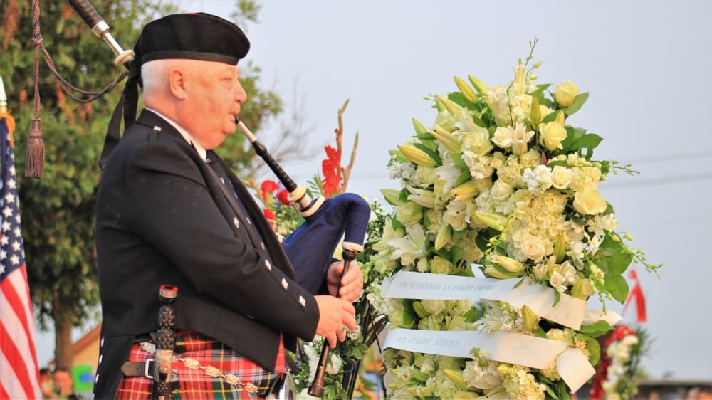 A bagpiper played while aircraft flew in the Missing Man formation. (Sandra Sadek/Community Impact Newspaper)