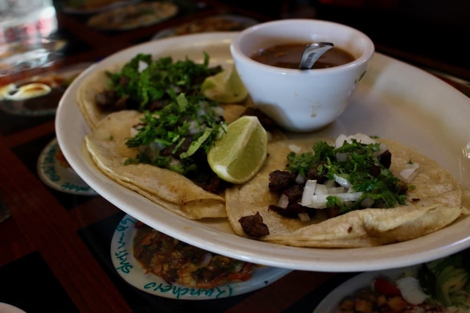 Tacos ($8.99) are served with a choice of meat, onions, and a side of rice and beans. (Chandler France/Community Impact Newspaper)