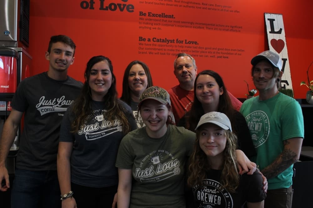 Co-owners John and Tamara Hamilton (middle back row) opened Just Love Coffee Cafe in November 2020 wanting to provide a family environment for the community. (Chandler France/Community Impact Newspaper)