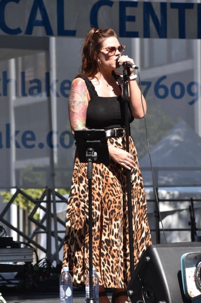 a woman sings onstage at Art in the Square
