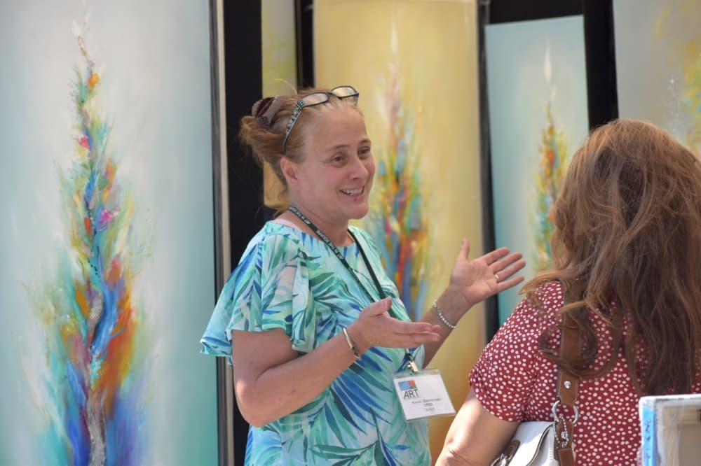a woman stands in front of paintings