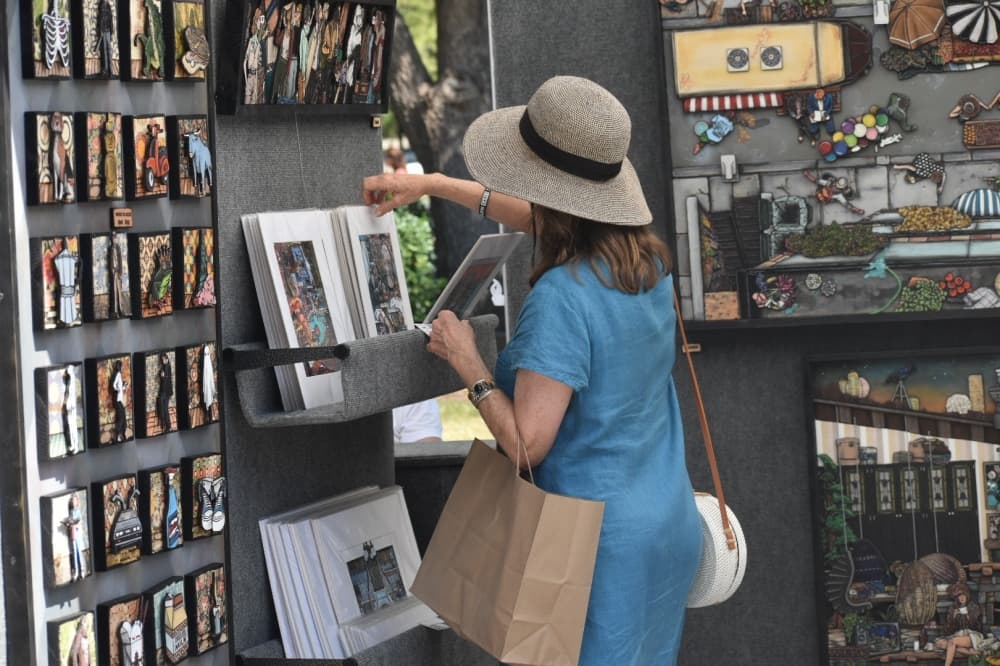 a woman looks at art prints