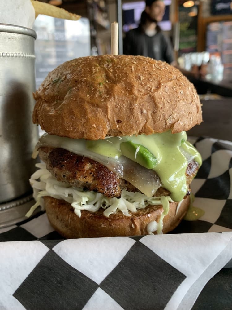 The Gobbler ($9) is a turkey patty that comes with sliced tomato, red onion, swiss cheese, sliced avocado and basil aioli served on a wheat bun. (Nicole Barron/Community Impact Newspaper)