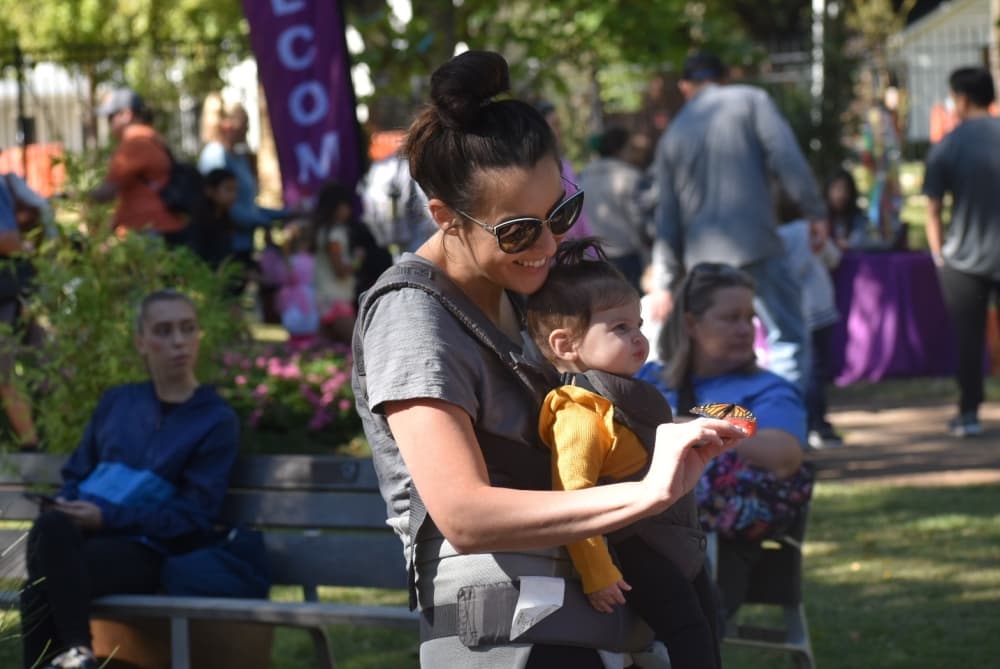 Alisa Dodson shows her child a butterfly at Butterfly Flutterby. (Anjali Krishna/Community Impact Newspaper)