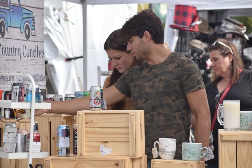 Nathan Upadhyay and Mallory Laurant look at candles at Oktoberfest. (Anjali Krishna/Community Impact Newspaper)
