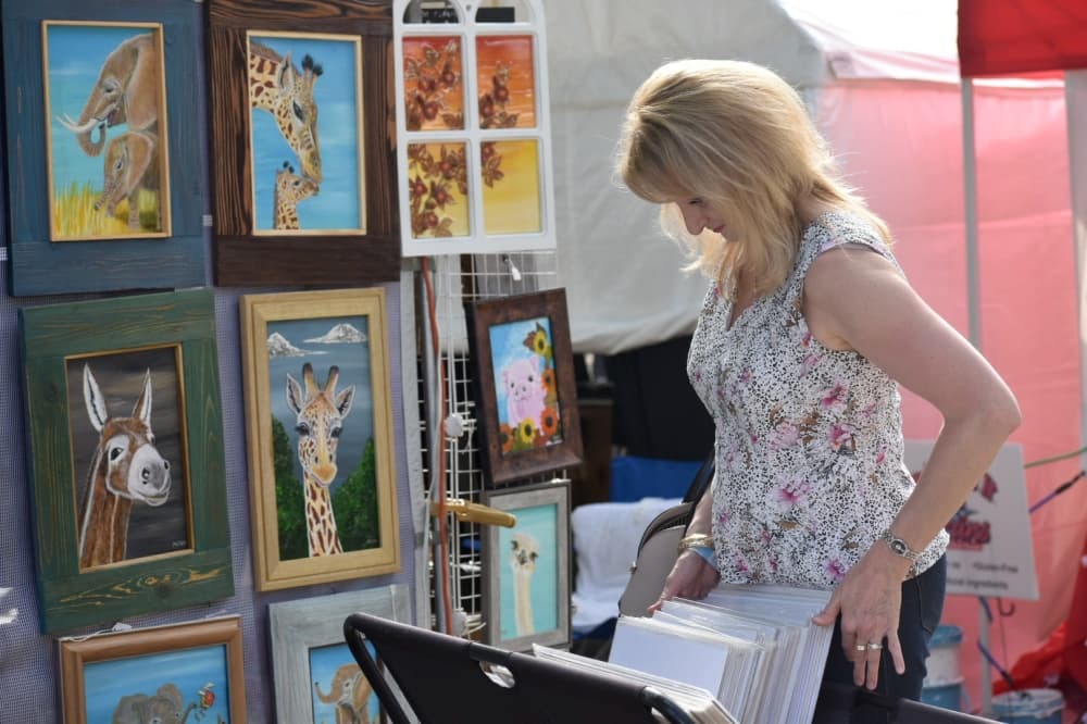 Elizabeth Symons looks at prints at Oktoberfest. (Anjali Krishna/Community Impact Newspaper)