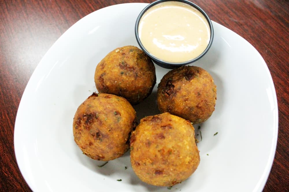 To make Boudin Balls ($9.99), pork sausage, rice and seasoning are rolled, breaded and deep fried. (Hannah Zedaker/Community Impact Newspaper) 