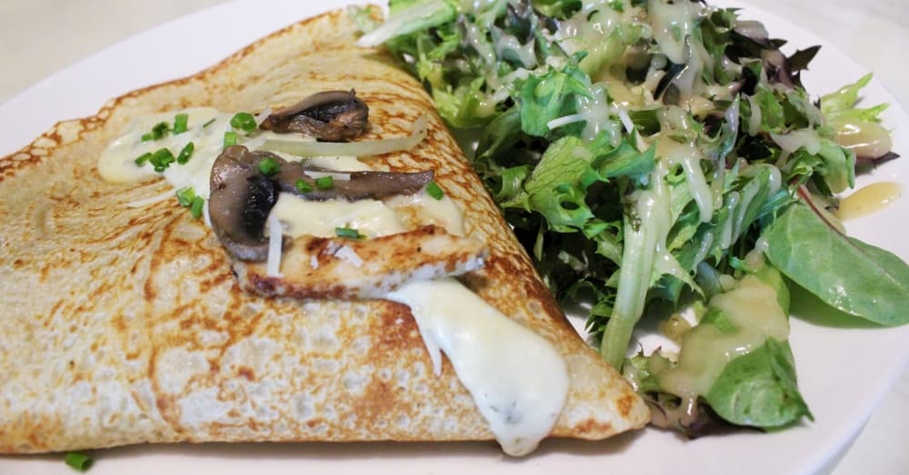 The Chicken Florentine ($9.95) is one of eight savory crepe options and is filled with grilled chicken, onions, creamy Florentine sauce and mozzarella cheese. (Hannah Zedaker/Community Impact Newspaper)