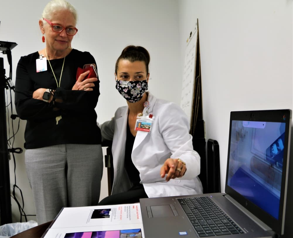 Professor Danielle Quintana shows Dean Tart virtual reality programs that allow students to experience the demands of operating room nurses. 