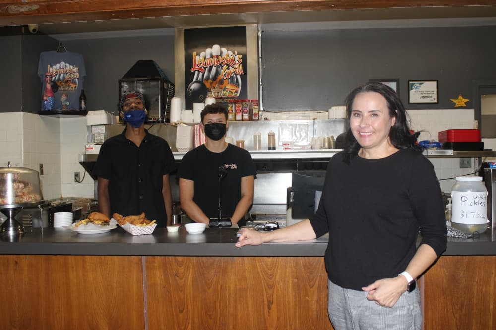 Helen Alder, owner of Lebowski's Grill, poses with her son Andrew Alger and another employee, Tim White. (Olivia Aldridge/Community Impact Newspaper)
