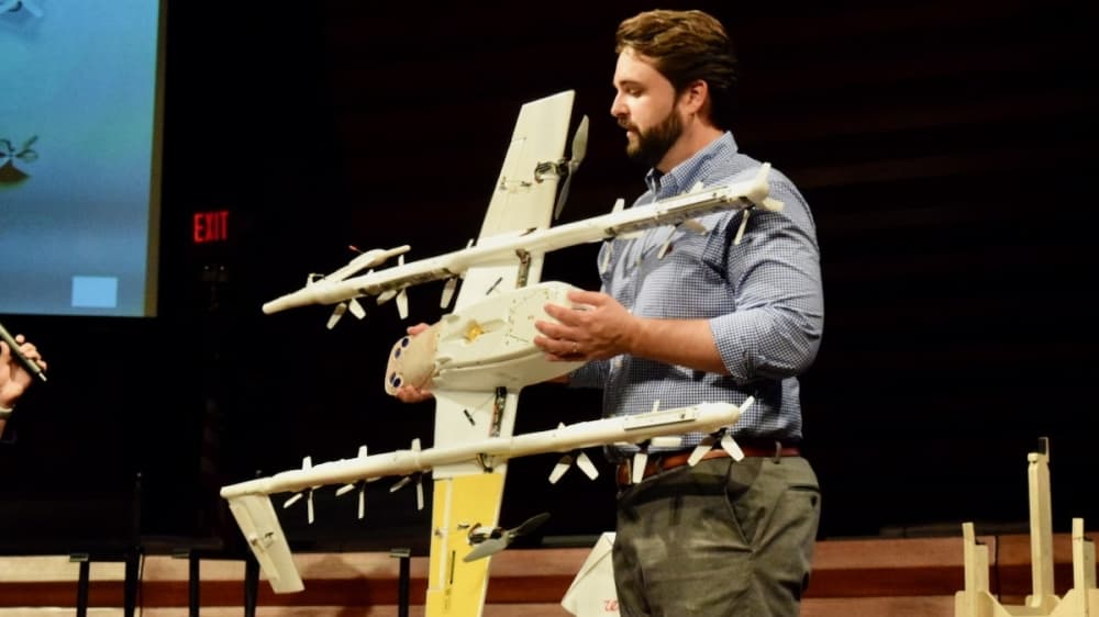 Jacob Demmitt, marketing and communications manager at Wing, holds one of the company's delivery drones in a town hall at the George A. Purefoy Municipal Center. (Matt Payne/Community Impact Newspaper)
