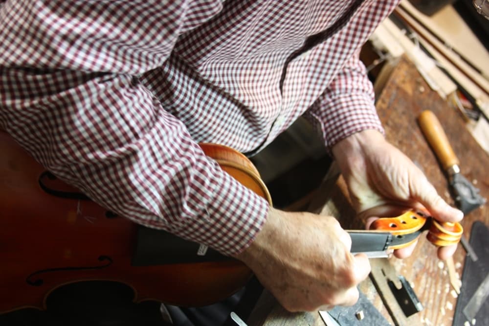 
The nut at the top of the neck that aligns the strings on the fretboard must be filed for proper action.