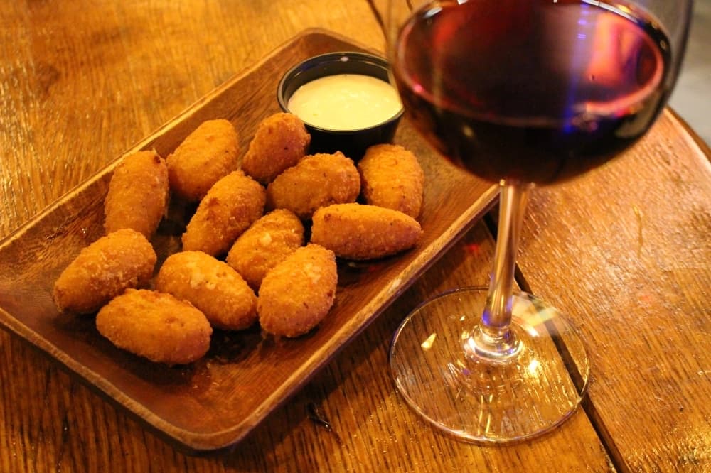 Bacon mac and gouda bites ($7) are among the snack items on the Cosmic Cowboy Lounge's menu. (Andrew Christman/Community Impact Newspaper)
