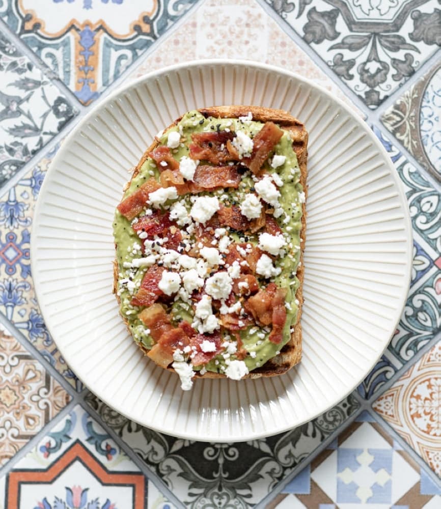 Hebrews Coffeehouse also offers multiple food items, such as avocado toast ($6.95), which is served with bacon and feta cheese on whole grain bread. (Courtesy Hebrews Coffeehouse)