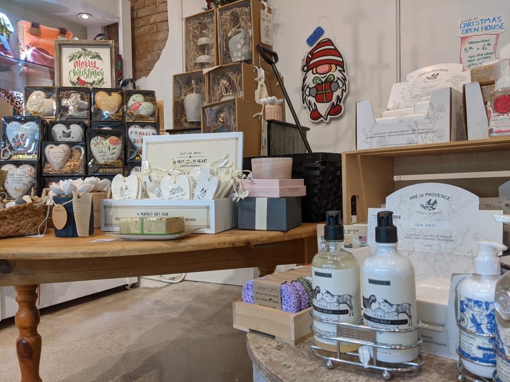 Various lotions and soaps sit on a display next to home decor items.