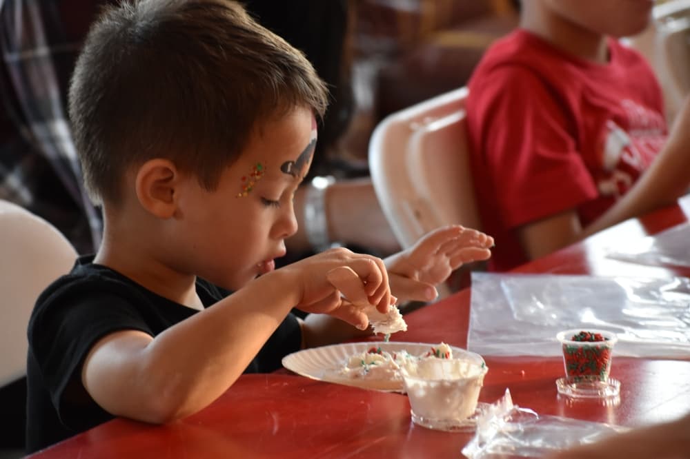 Grayson Lee decorates a cookie at Roanoke's Hometown Holiday event. (Anjali Krishna/Community Impact)