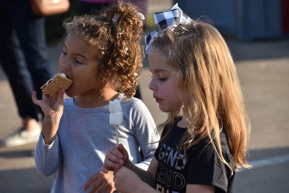 Two attendees enjoy s'mores at Roanoke's Hometown Holiday event. (Anjali Krishna/Community Impact)
