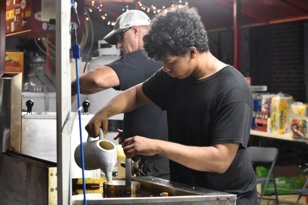 Derek Martinez makes funnel cakes at Roanoke's Hometown Holiday event Dec. 4. (Anjali Krishna/Community Impact)