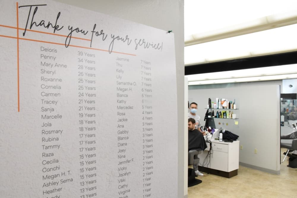 A plaque on the wall of Beautique lists the names of all employees with how long they have worked there. (Hunter Marrow/Community Impact Newspaper)