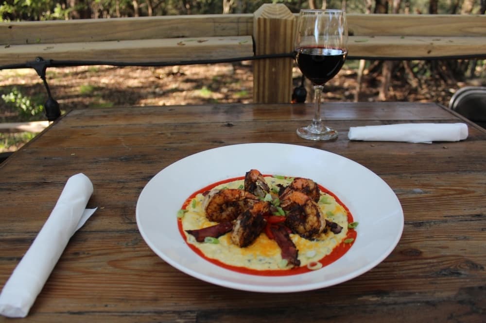 The blackened shrimp and grits ($18.95) comes with ham, poblano cheese grits, onions and a red pepper puree. (Eric Weilbacher/Community Impact Newspaper)