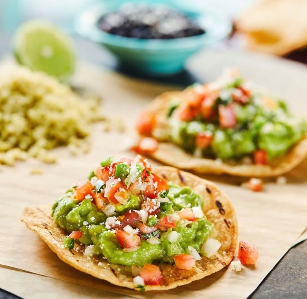The avocado toast-ada sits on a crispy round corn tortillas topped with a generous scoop of homemade guacamole, pico de gallo & cotija cheese and comes served with black beans and poblano lime rice. (Courtesy Blue Goose Cantina)