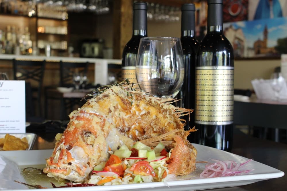 The huachinango al ajillo ($36)  is a garlic-citrus marinated red snapper, lightly fried and served with curtido de habanero, avocado, cucumber, tomato, and tortillas. (Ally Bolender/Community Impact Newspaper)