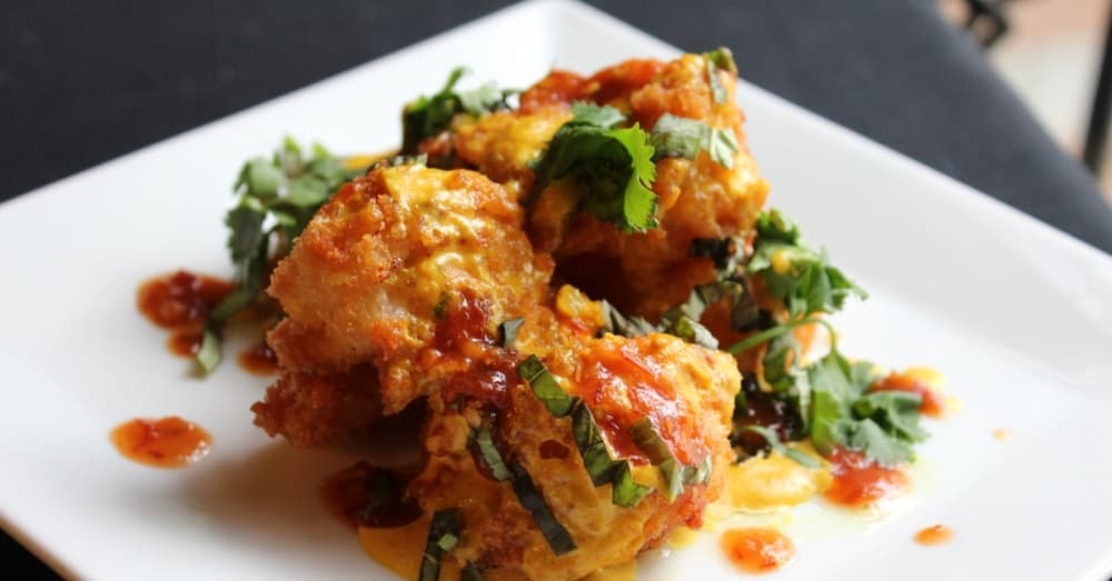 Spicy garlic shrimp ($10): Lightly fried shrimp topped in chili-garlic aioli and pepperoncini is a staple at Elm & Magnolia. (Emily Lincke/Community Impact Newspaper)