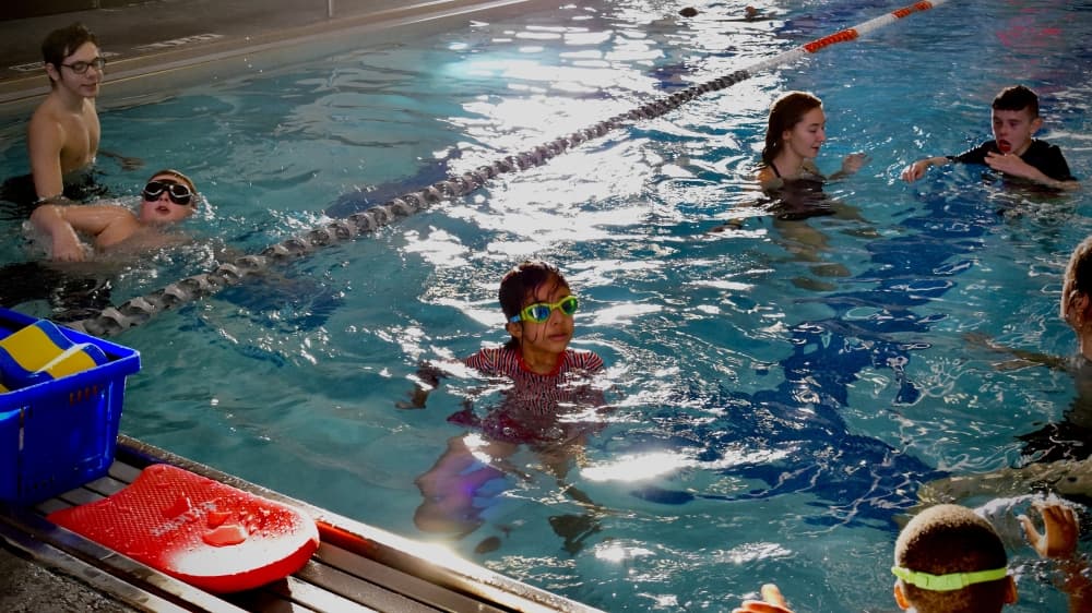 Viana Dowlatabadi (middle) participates in a children's swim lesson at the McKinney Senior Recreation Center pool. (Matt Payne/Community Impact Newspaper)