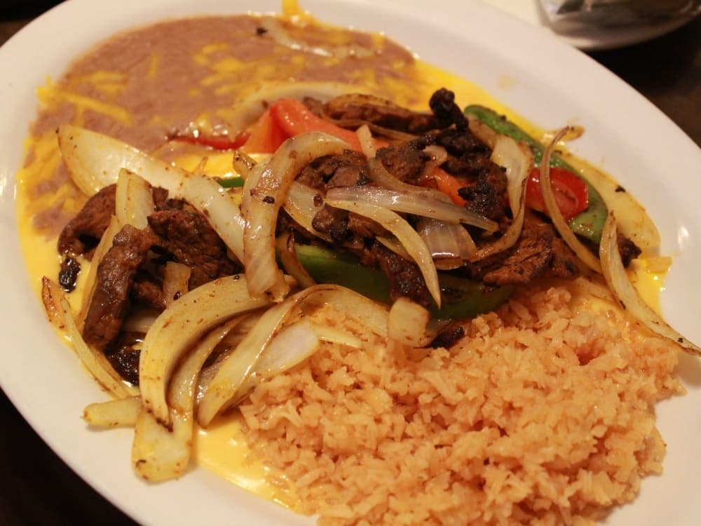 Cowboy’s Special ($13) has cheese enchiladas with chili or queso sauce, topped with fajita chicken or steak. (Sandra Sadek/Community Impact Newspaper)
