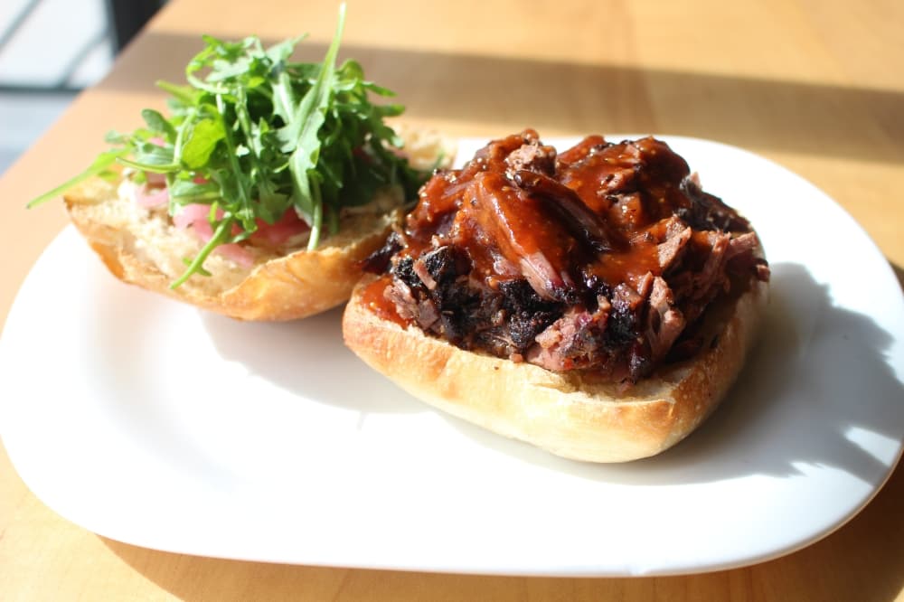 The brisket sandwich ($9.50) is served on a ciabatta bun with fresh greens. (Andrew Christman/Community Impact Newspaper)