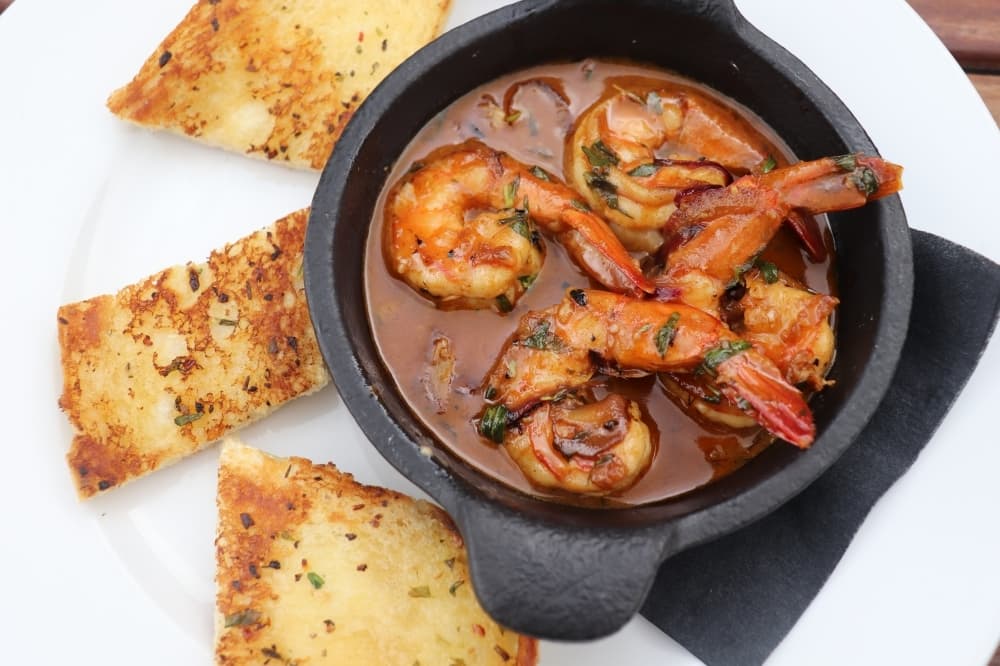 
The n.o.b.s., New Orleans BBQ shrimp, is served with a side of bread simmered in a garlic and lemon sauce.