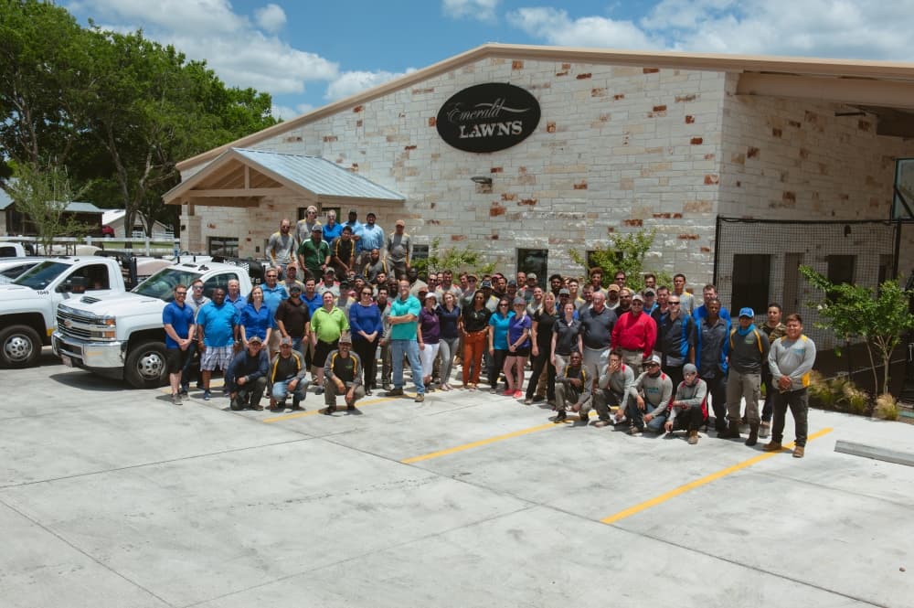 emerald lawns employees gather outside of their company headquarters