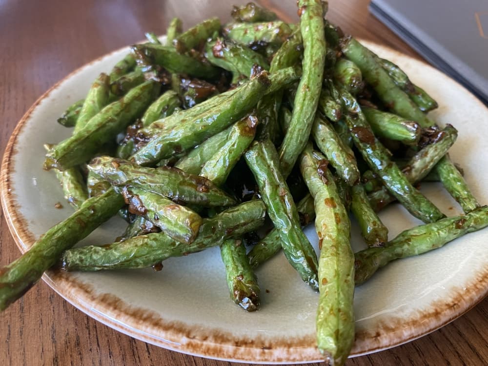 One popular dish is local green beans flash fried then tossed with fermented mustard greens. (Darcy Sprague/Community Impact Newspaper)