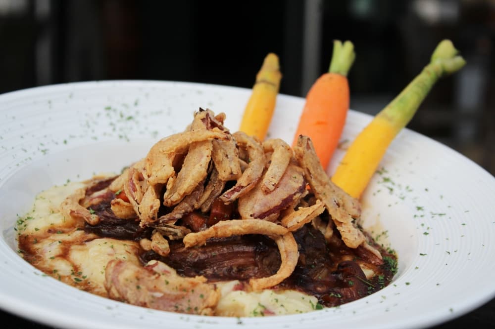 Short rib pot roast ($20) has blue cheese whipped potatoes, roasted root vegetables, crispy fried shallots and a red wine demi-glaze. (Karen Chaney/Community Impact Newspaper)