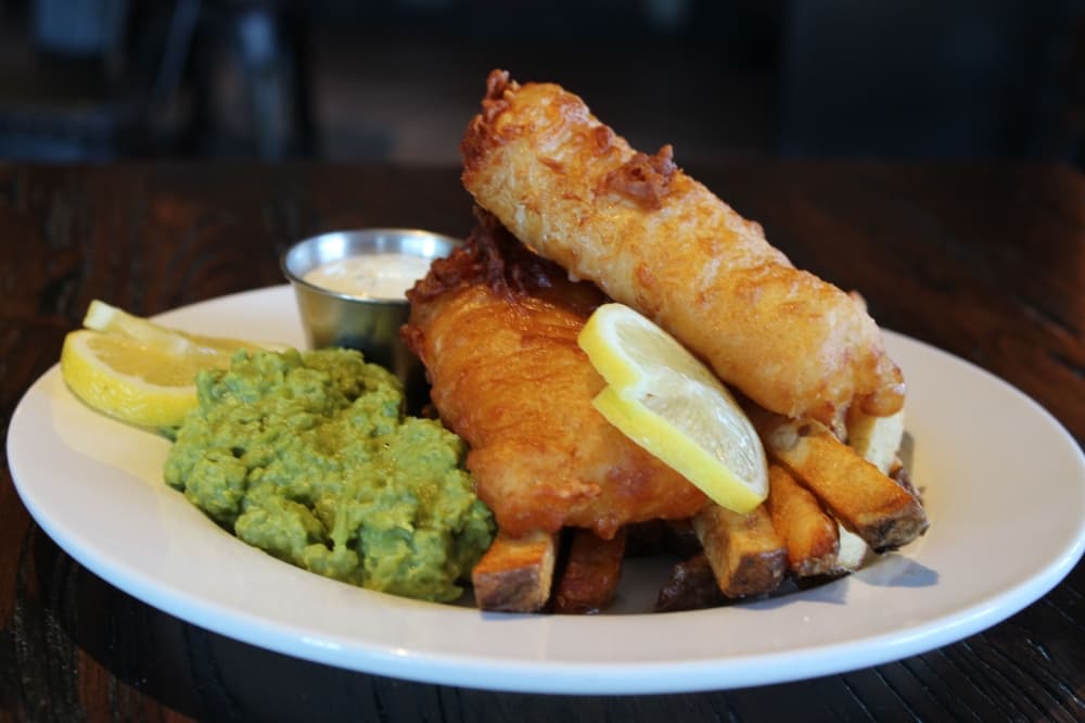 Fish and chips ($15) includes beer-battered cod with French fries, mushy peas, regular peas or coleslaw. (Karen Chaney/Community Impact Newspaper)