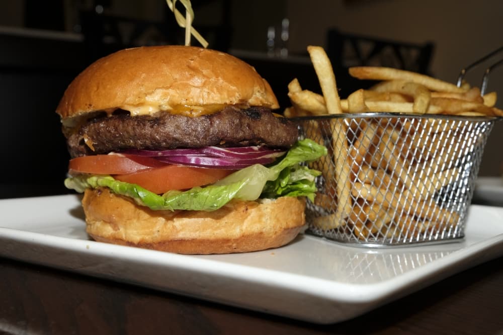 The OG Burger ($12.95): An 8-ounce beef patty is served on a challah bun with lettuce, tomato, onions, melted cheese and a New York Eatery housemade sauce called OG Sauce. (George Wiebe Community Impact Newspaper)