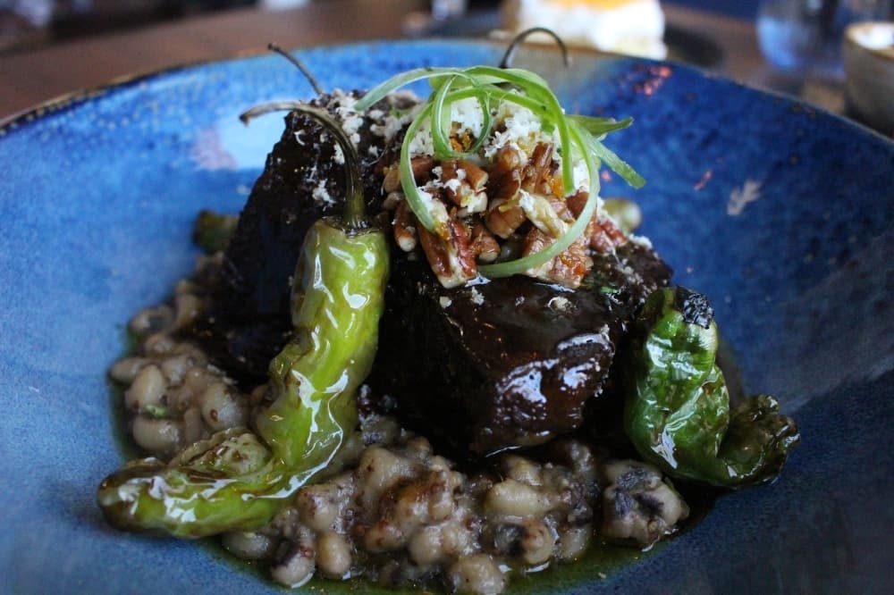 The six-hour Bordeaux-braised chuck short ribs ($42) are served with black eyed-peas, pecan gremolata and fresh horseradish. 
