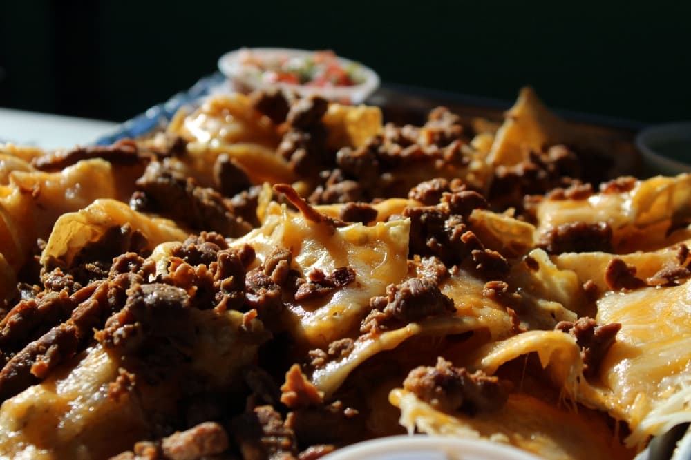 Nachos ($8-$10) come with a choice of chicken, al pastor pork, steak or tamales. They are served with pico de gallo, sour cream, avocado salsa and arbol salsa. (Karen Chaney/Community Impact Newspaper)