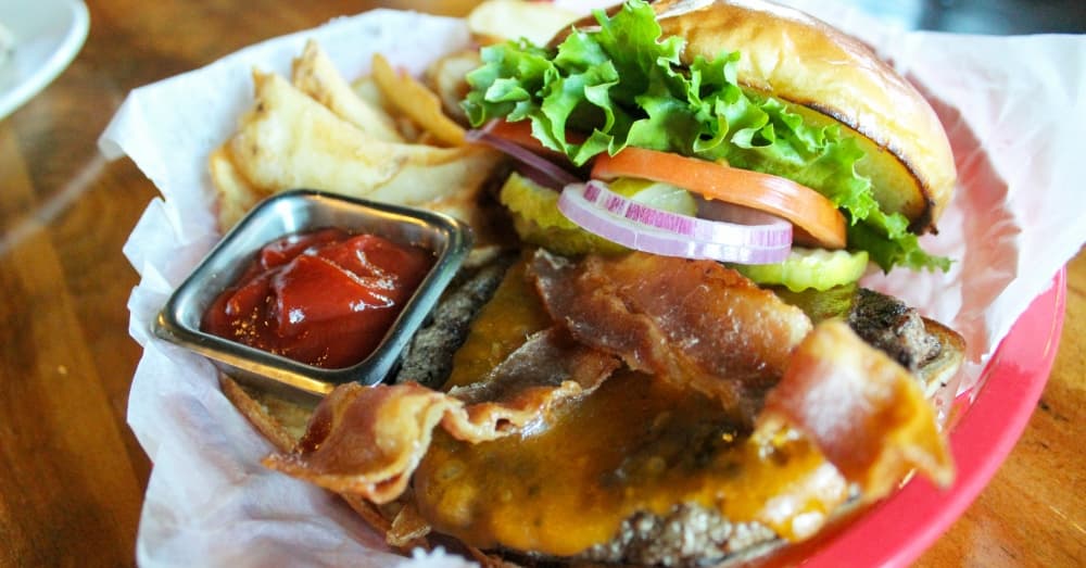 The Wunsche Burger ($11.75): A recipe that is about 40 years old, this 1-inch-thick beef patty is topped with lettuce, tomatoes, red onion and pickles, all piled onto a brioche bun. (Emily Lincke/Community Impact Newspaper)