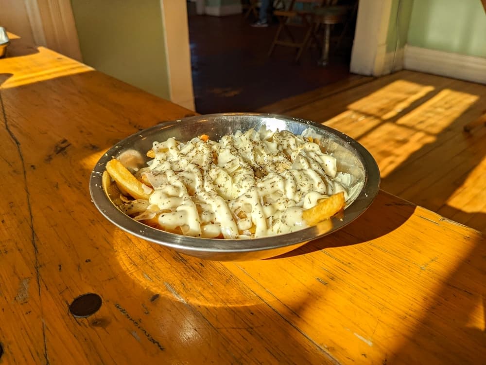 Garlic Parmesan Fries feature Parmesan cheese and Italian herbs layered over fries. The garlic Parmesan dressing is also available with tater tots.