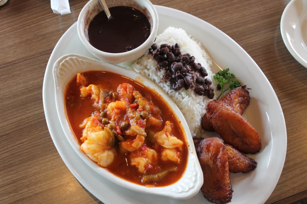 Camarónes Enchilados ($19.50): Shrimp is served in a Creole sauce with white rice, black beans and the choice of one side.