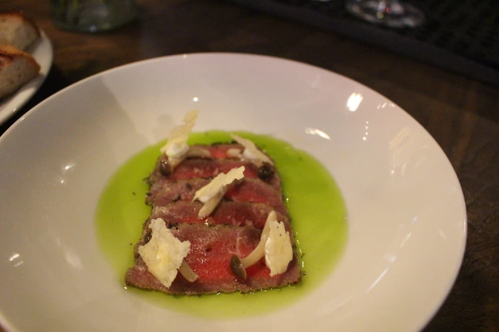 Beef Carpaccio ($14): Italian-style roast beef rub is served with horseradish creme fraiche, marinated beech mushrooms, chive oil and parmesan crisp. (Sofia Gonzalez/Community Impact Newspaper)