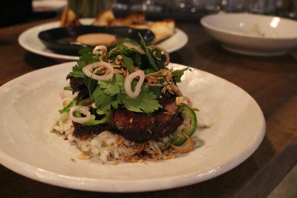Steak ($28): A 44 Farms Denver Cut is served with beef fat rice, herbs and a fish sauce glaze. (Sofia Gonzalez/Community Impact Newspaper)