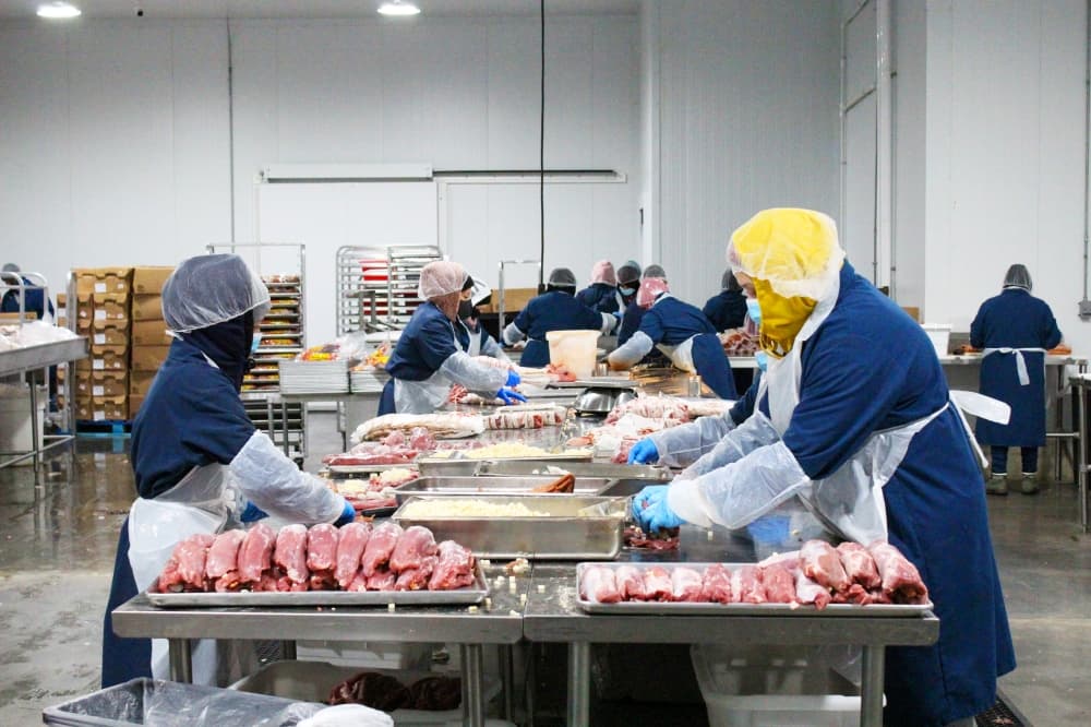 Employees package products to be sold commercially in grocery stores. (Emily Lincke/Community Impact Newspaper)